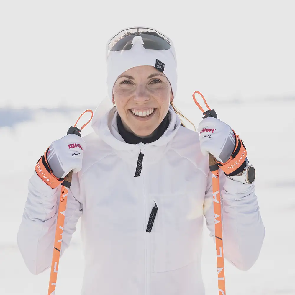 Crosscountry skier with ski clothes and sports glasses in white