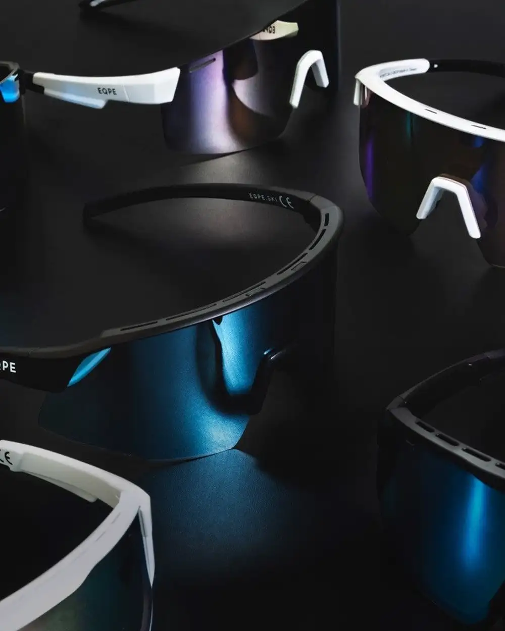 Sunglasses with mirrored lenses in various colors, displayed on a dark background.